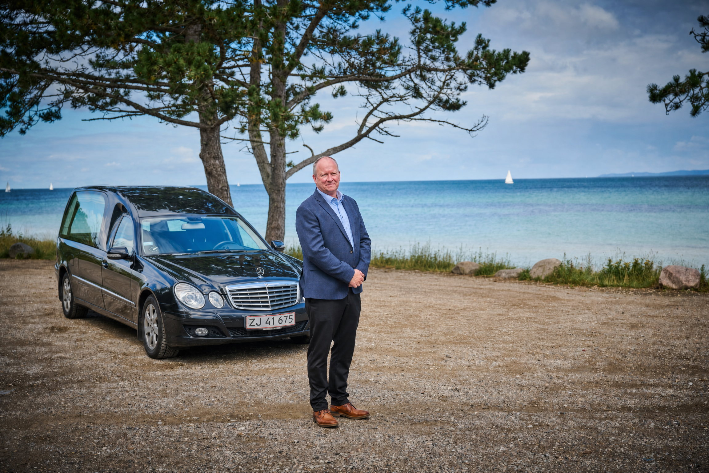 Kim Bondo med sort Mercedes rustvogn ved den danske kyst